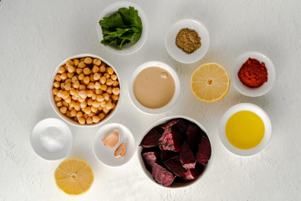 roasted beet hummus ingredients in bowls on a white background