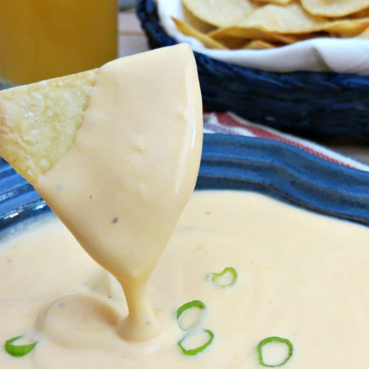 pita chip being dipped in beer cheese dip