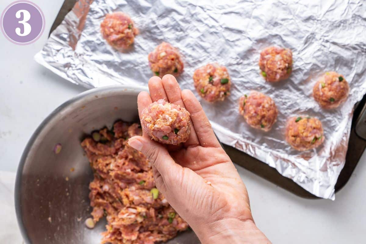 rolling Asian meatballs and placing them on a baking sheet